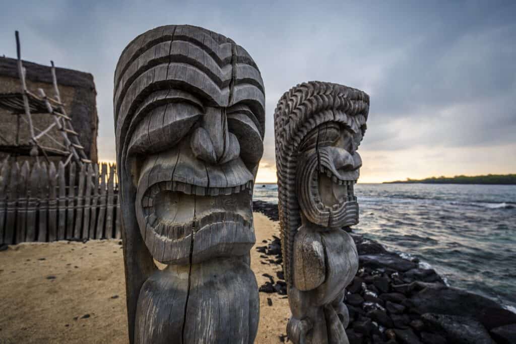 Traditional Tiki statues on Big Island Hawaii beachfront, showcasing Polynesian culture and coastal.