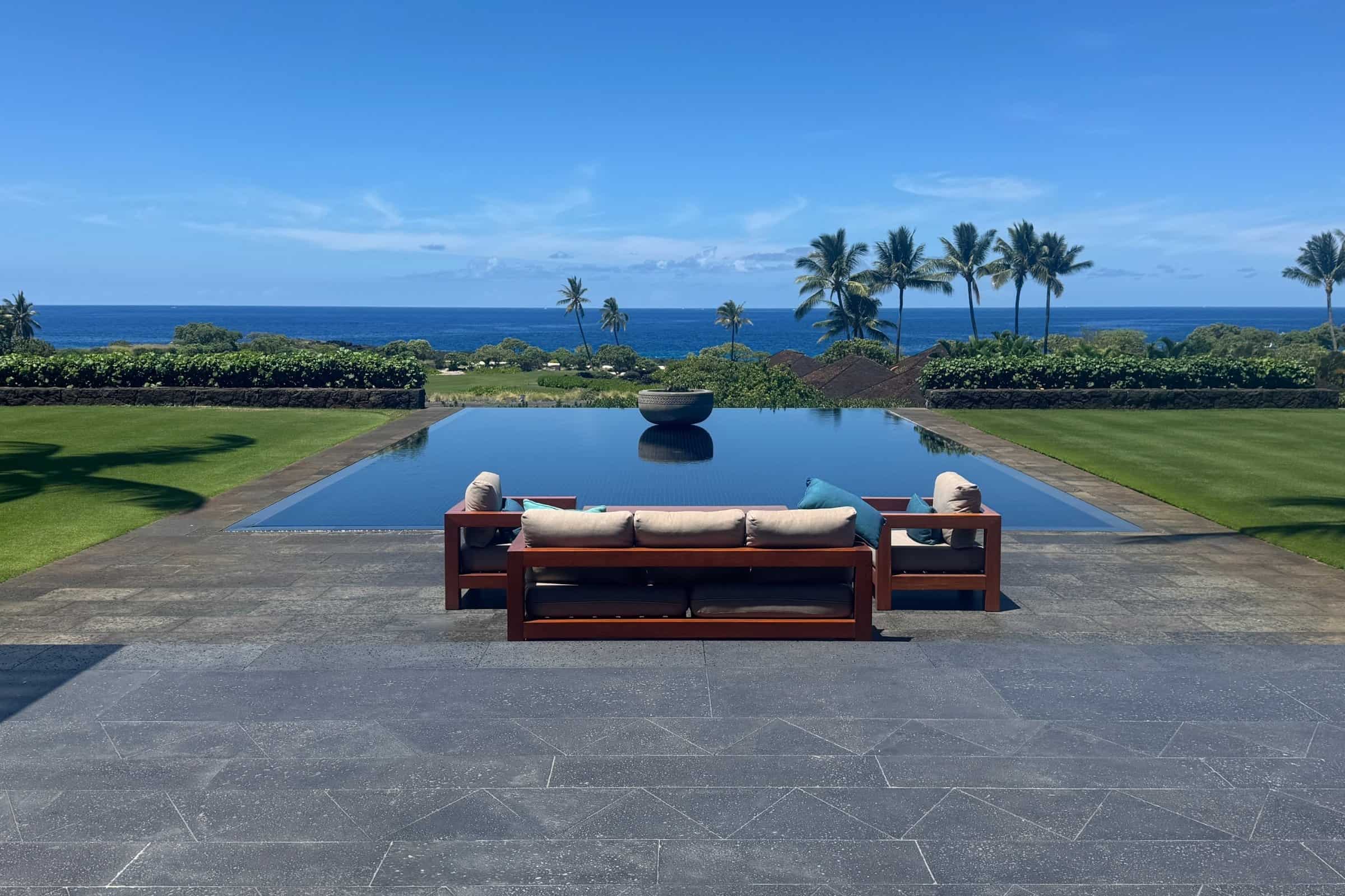 Infinity pool and daybed looking out to the ocean at a Kohanaiki home.