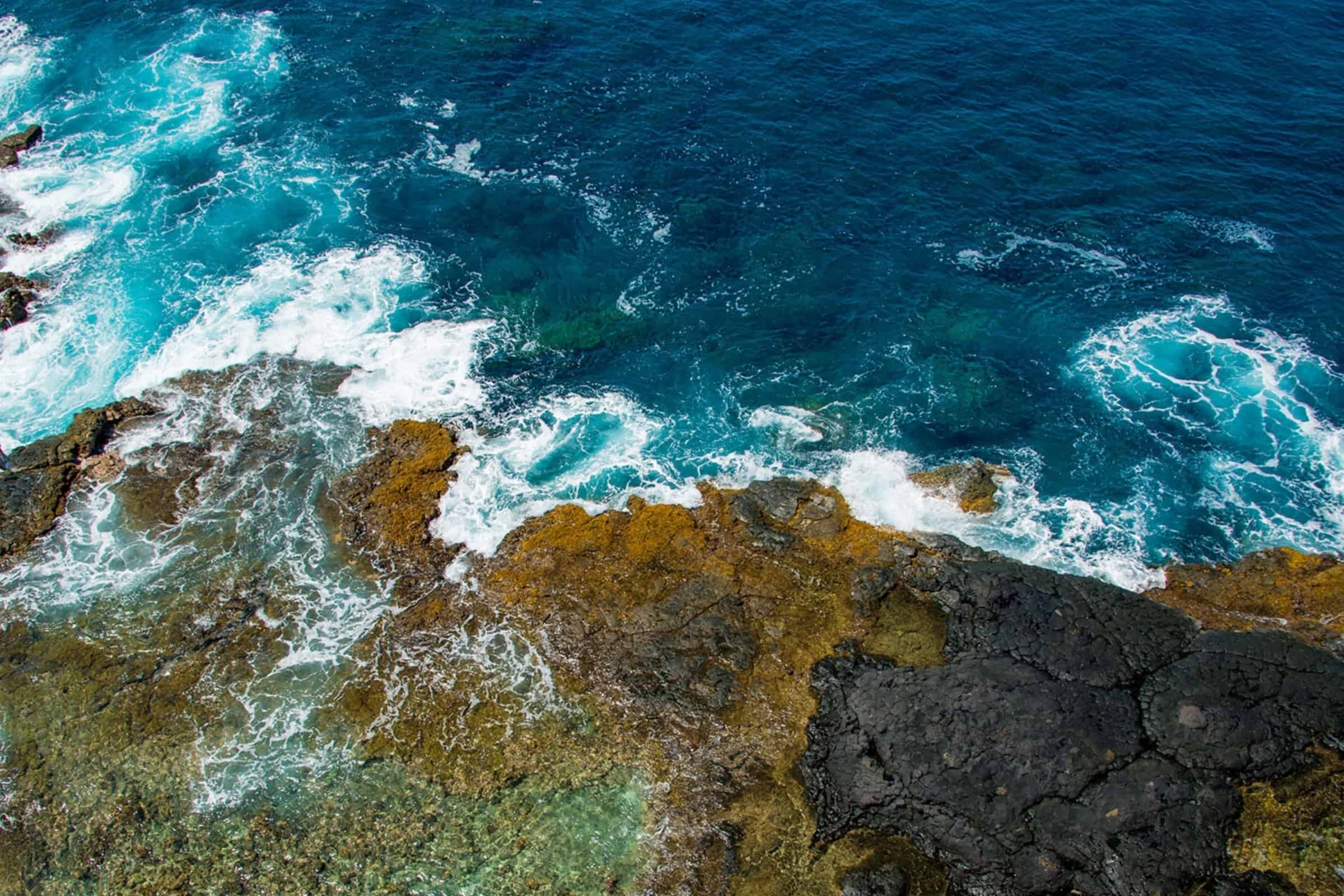 Coastal rocks and ocean waves in Kona, Big Island Hawaii, showcasing island's natural beauty and oce.