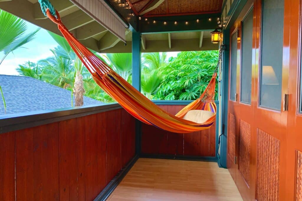 Hawaii Big Island real estate: Kona and Kohala Coast balcony with hammock, lush greenery, and island.
