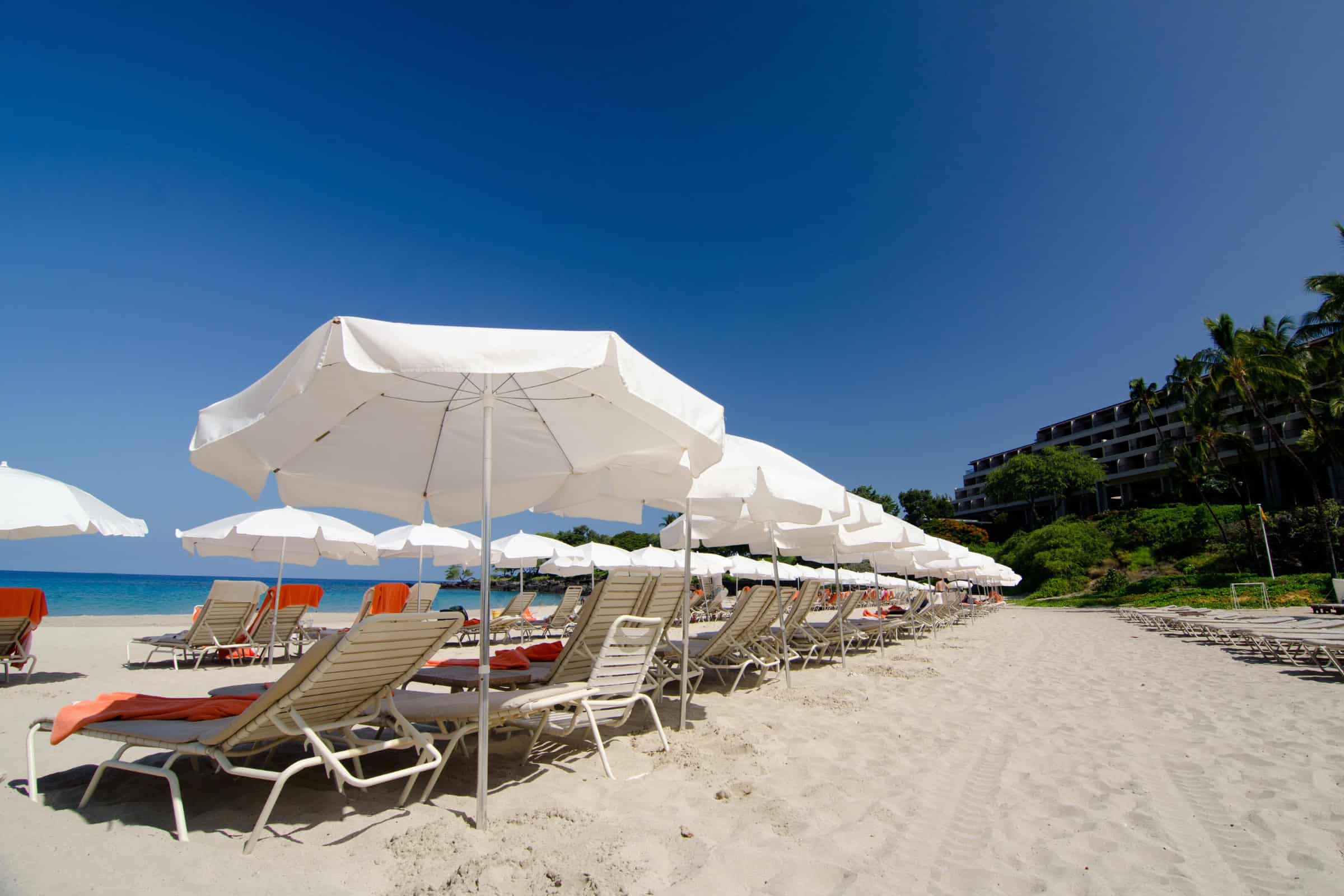 Oceanfront resort beach chairs and umbrellas in Kona, Big Island Hawaii.