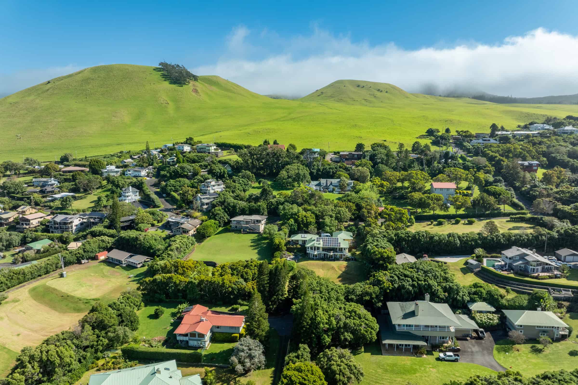 Luxury homes in Kona and Kohala Coast with lush green hills and ocean views.
