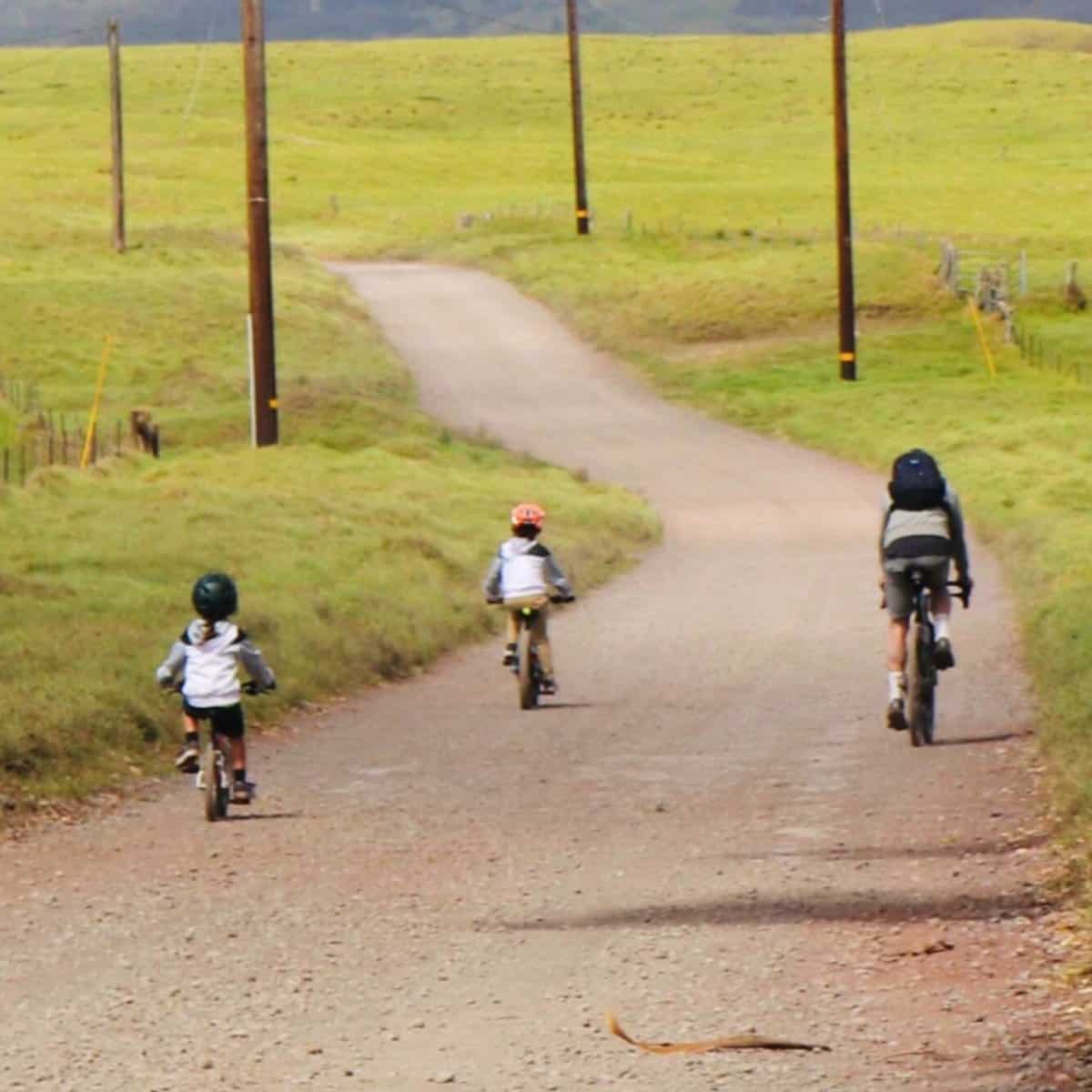 Penn Henderson riding Mana Road above Waimea with his kids on the Big Island of Hawaii