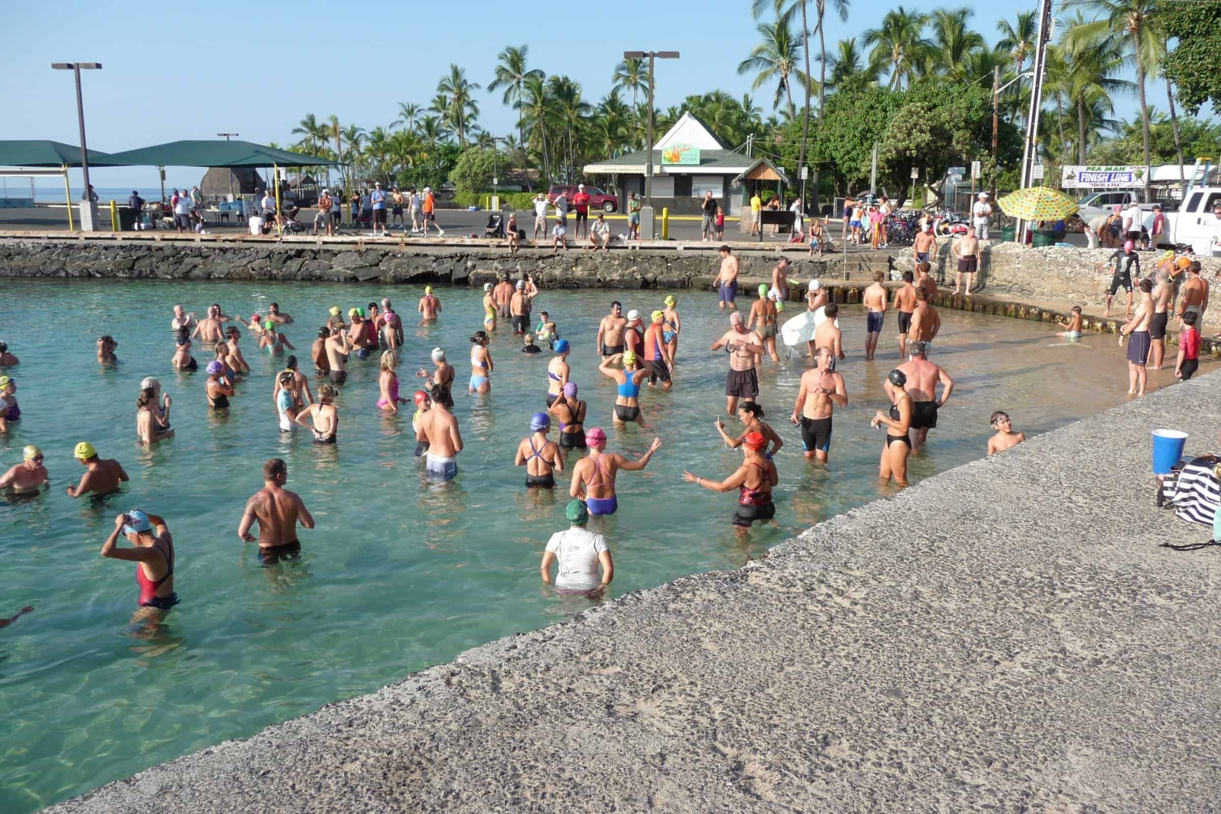 Swimmers wading in for the start of a Peaman biathlon at Kailua Bay in Kona.