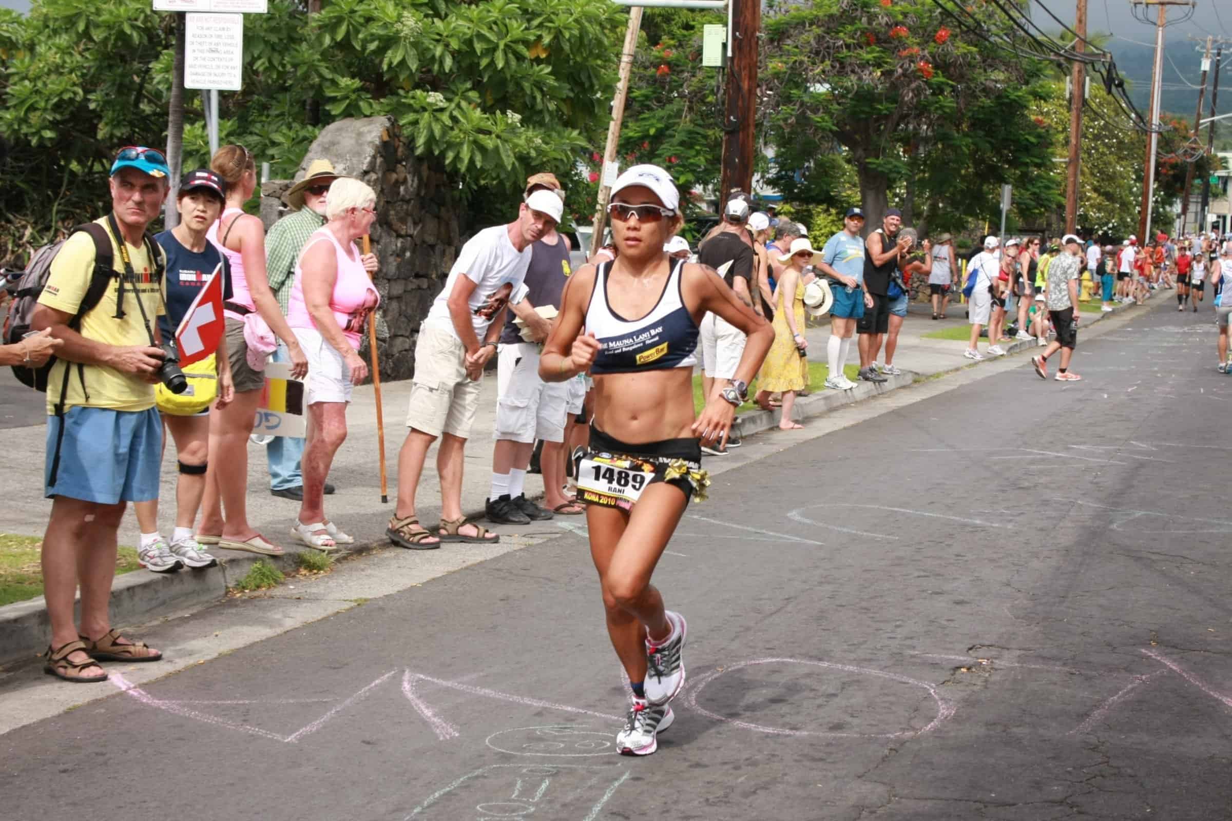 Rani Henderson running through spectators lining Aliʻi Drive at the 2010 IRONMAN™ World Championship.