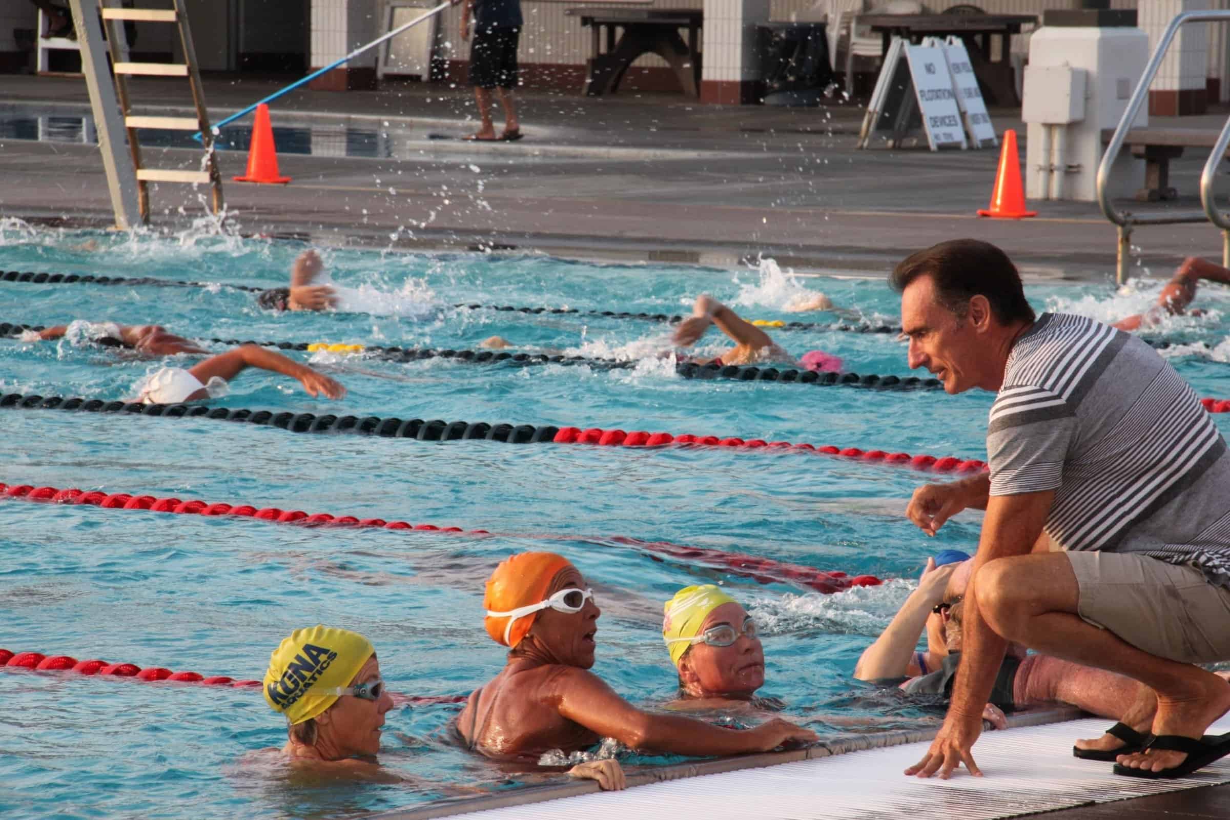 Masters swimmers working through a set in the lap pool at Kailua-Kona with a coach on deck.